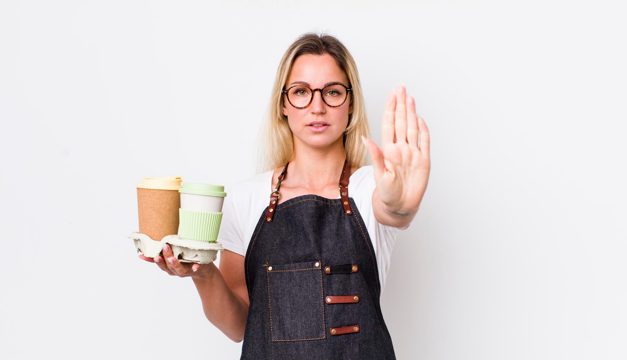 Looking serious showing open palm making stop gesture