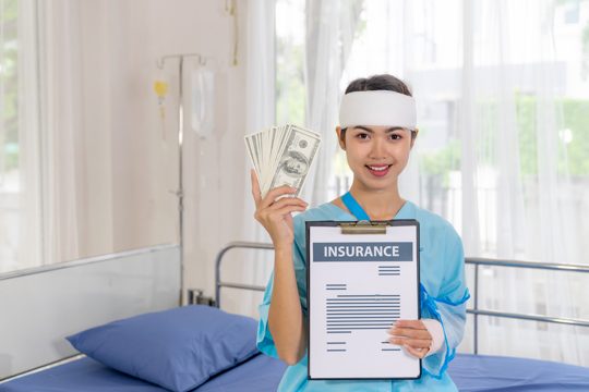 Accident patients injury  woman on patient's bed in hospital  holding us dollar bills feel happy from getting insurance money from insurance companies- medical concept