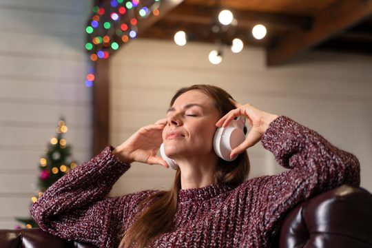 Woman listening to christmas music on headphones