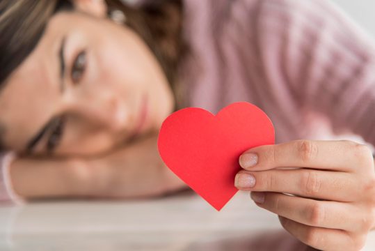 Close-up blurred woman holding heart