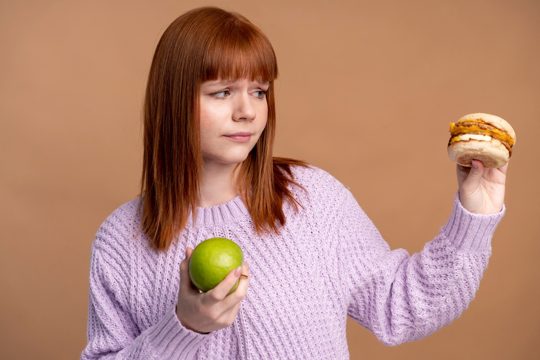 Woman with eating disorder deciding which food to eat