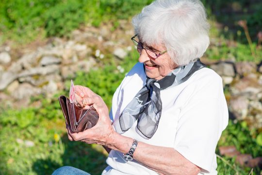 Senior woman looking for something in her purse