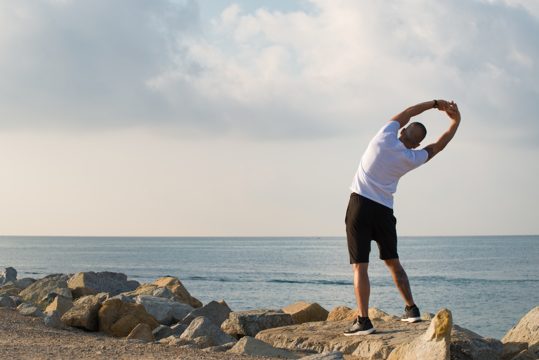 Rear view of man doing low-intensity warm-up