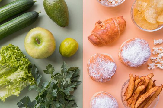 Top view green fruits and vegetables with unhealthy snack