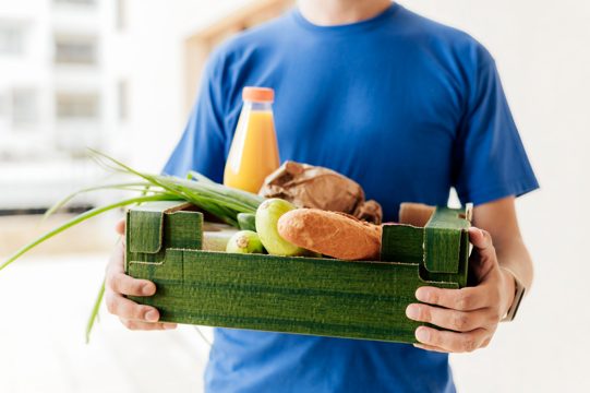 Close-up man holding food crate