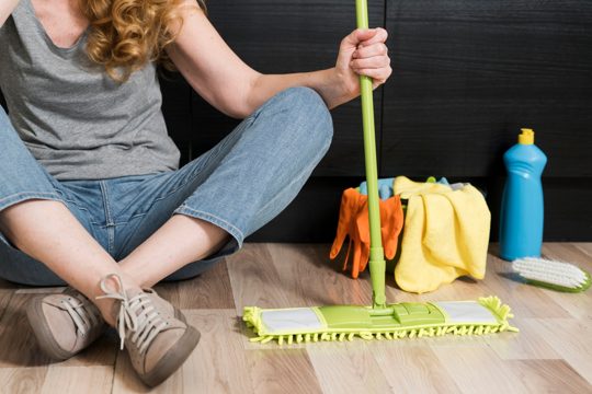Front view of woman holding mop